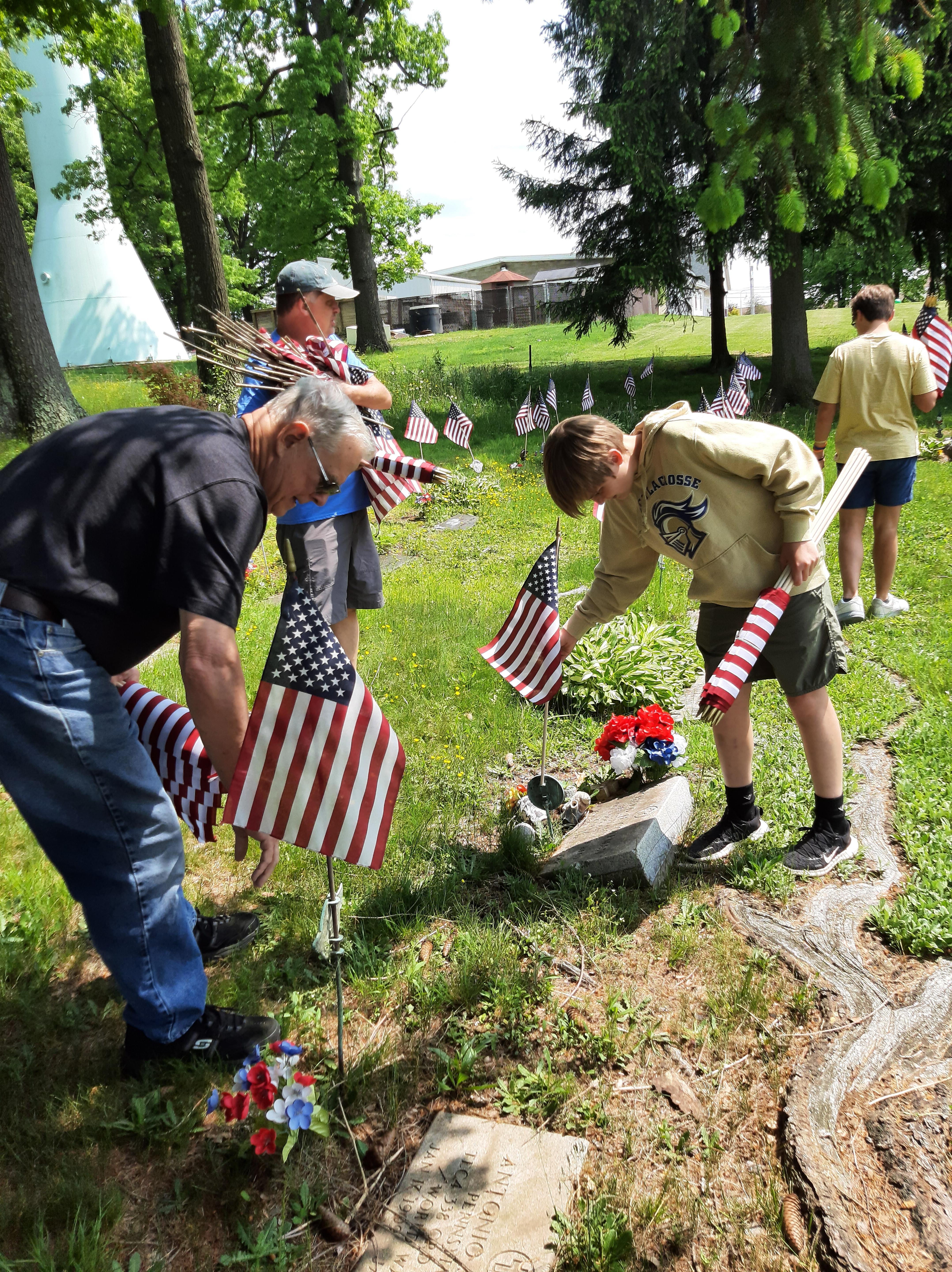 pic of people replacing flags on graves